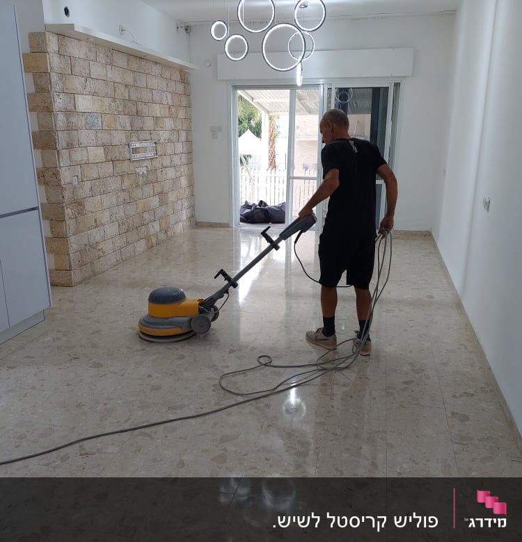 אדם מנקה רצפה עם מכונת פוליש חשמלית